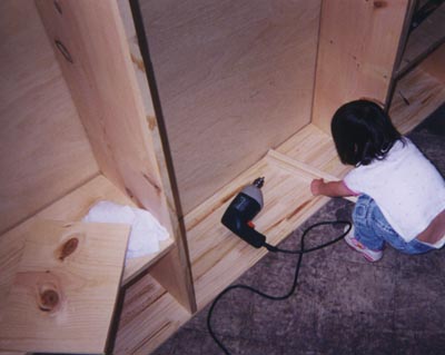 mary helping with wood working shelves